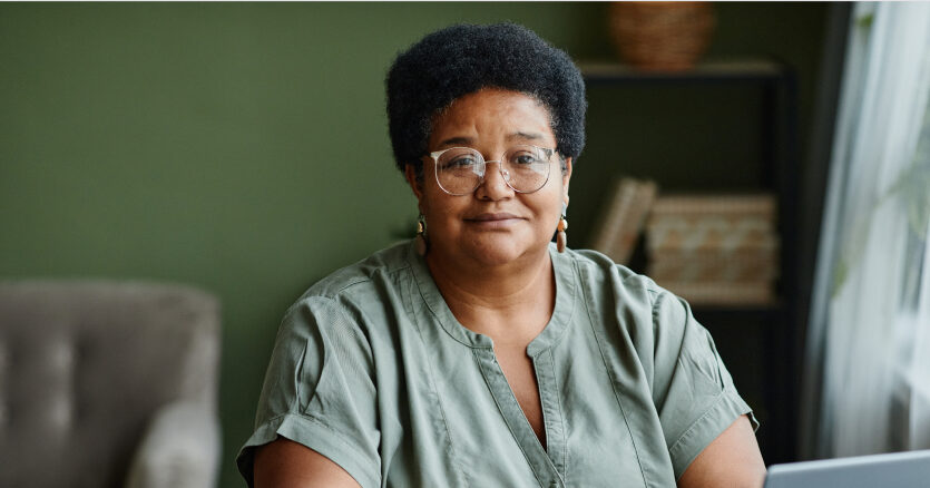A woman sitting in a living room, looking at you