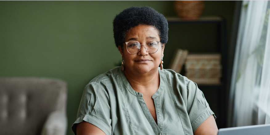 A woman sitting in a living room, looking at you